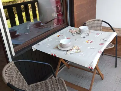 a table with cups and plates on a balcony at Studio cabine pour 4 pers, animaux acceptés, internet, vue montagne - FR-1-629-136 in Samoëns