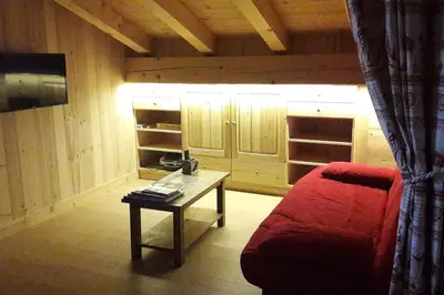 a living room with a red couch and a table at Appartement sur les pistes de Megève in Megève