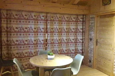 a table and chairs in a room with a wallpaper at Appartement sur les pistes de Megève in Megève