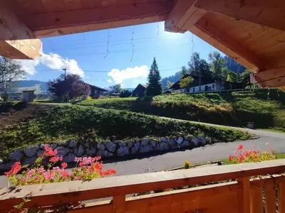a view from a porch of a garden with flowers at Appartement sur les pistes de Megève in Megève