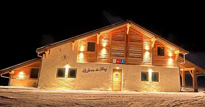 a building with lights on the side of it at La Ferme du Praz in Les Contamines-Montjoie