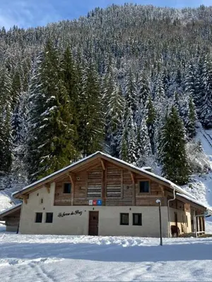 a house in the snow with trees in the background at La Ferme du Praz in Les Contamines-Montjoie