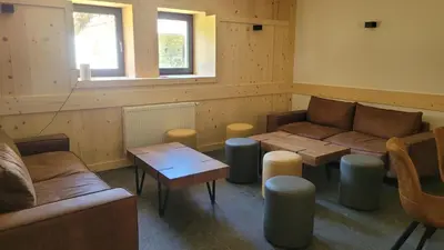 a living room with couches and tables and a window at La Ferme du Praz in Les Contamines-Montjoie