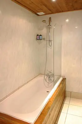 a bath tub with a shower in a bathroom at Ideal For all type of families 