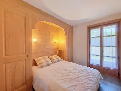 a bedroom with a white bed and a window at Appartement 2 chambres avec jardin au pied du Mont Blanc - FR-1-560-144 in Combloux
