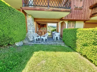 a house with a porch with a table and chairs at Appartement 2 chambres avec jardin au pied du Mont Blanc - FR-1-560-144 in Combloux