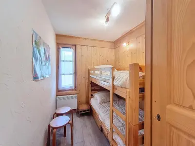 a bedroom with two bunk beds and a stool at Appartement 2 chambres avec jardin au pied du Mont Blanc - FR-1-560-144 in Combloux