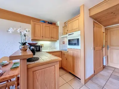 a kitchen with wooden cabinets and a wooden table at Appartement 2 chambres avec jardin au pied du Mont Blanc - FR-1-560-144 in Combloux