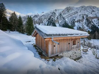 a small cabin in the snow with mountains in the background at Petit Mazot La Chandelle - OVO Network in Bionnassay