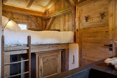 a bedroom in a wooden cabin with a bunk bed at Petit Mazot La Chandelle - OVO Network in Bionnassay