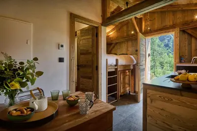 a kitchen with wooden walls and a counter with fruit on it at Petit Mazot La Chandelle - OVO Network in Bionnassay