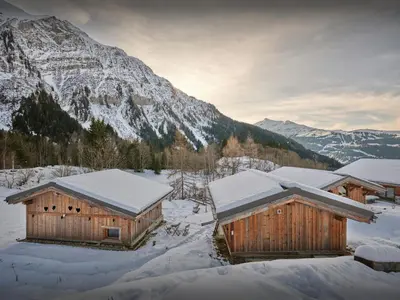 two wooden buildings in the snow with a mountain at Petit Mazot La Chandelle - OVO Network in Bionnassay