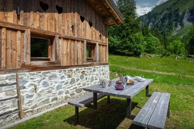 a picnic table in front of a stone building at Grand Mazot La Chandelle - OVO Network in Bionnassay