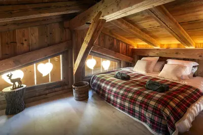 a bedroom with a bed in a log cabin at Grand Mazot La Chandelle - OVO Network in Bionnassay