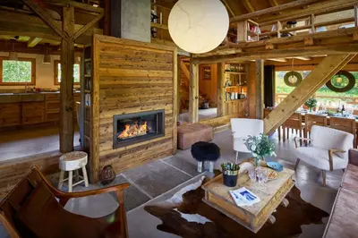 a living room with a fireplace in a log cabin at Chalet La Chandelle - OVO Network in Bionnassay