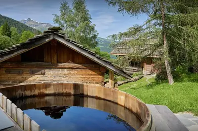 a pool of water in front of a wooden house at Chalet La Chandelle - OVO Network in Bionnassay