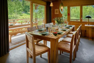 a wooden table in a room with a large window at Chalet La Chandelle - OVO Network in Bionnassay