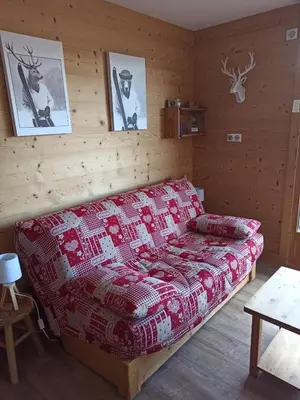 a bedroom with a bed with a red blanket at Le Cocon des Carroz, au centre de la station et proximité des pistes, apt 4 pers in Arâches-la-Frasse