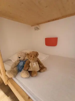 two teddy bears sitting on a bunk bed at Le Cocon des Carroz, au centre de la station et proximité des pistes, apt 4 pers in Arâches-la-Frasse