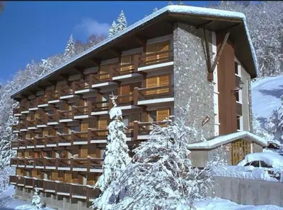 a building in the snow with snow covered trees at Le Cocon des Carroz, au centre de la station et proximité des pistes, apt 4 pers in Arâches-la-Frasse