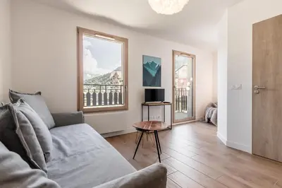 a living room with a couch and a window at Le 202 - Proche telecabine - Vue Montagne in Saint-Gervais-les-Bains