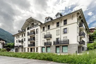 an apartment building with balconies and a parking lot at Le 202 - Proche telecabine - Vue Montagne in Saint-Gervais-les-Bains