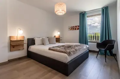 a bedroom with a bed and a window and a chair at Le 203 - Proche telecabine - centre ville in Saint-Gervais-les-Bains