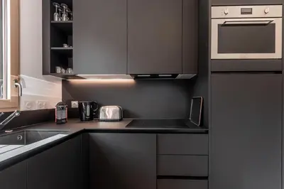 a kitchen with black cabinets and a counter top at Le 203 - Proche telecabine - centre ville in Saint-Gervais-les-Bains