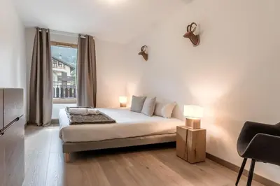 a white bedroom with a bed and a window at Le 203 - Proche telecabine - centre ville in Saint-Gervais-les-Bains