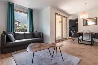a living room with a couch and a table at Le 203 - Proche telecabine - centre ville in Saint-Gervais-les-Bains