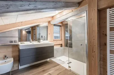 a kitchen with white cabinets and black counter tops at Chalet Hygge - Piscine - Calme in Saint-Gervais-les-Bains