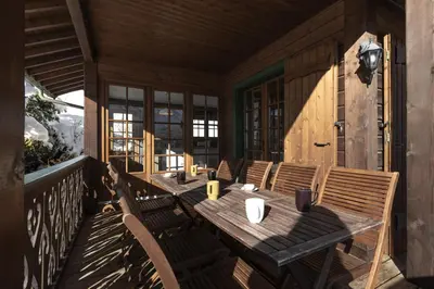 a wooden table and chairs on a porch at Chalet Marie Paradis vue Mont Blanc in Saint-Gervais-les-Bains
