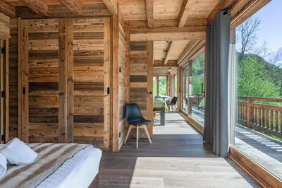 a room with a bed and a wooden wall at Chalet 1000 in Les Houches