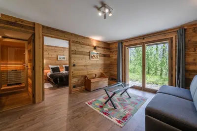 a living room with wooden walls and a couch and a table at Chalet 1000 in Les Houches