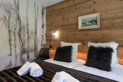 a hotel room with a bed with black pillows at Chalet 1000 in Les Houches