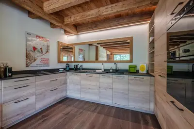 a large kitchen with wooden cabinets and wooden ceilings at Chalet 1000 in Les Houches