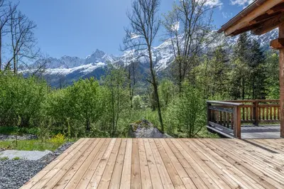 a wooden deck with mountains in the background at Chalet 1000 in Les Houches