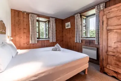 a bedroom with a large white bed with windows at La Poya Bas in Les Houches