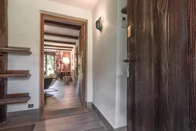 a hallway with a wooden door leading to a living room at La Poya Bas in Les Houches
