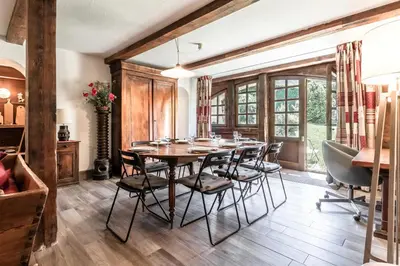 a dining room with a wooden table and chairs at La Poya Bas in Les Houches