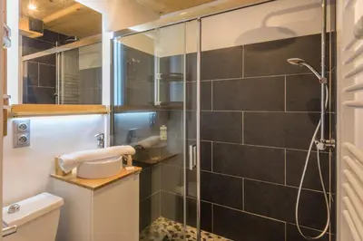a bathroom with a shower with a toilet and a sink at Appartement Rothschild - garage - Welkeys in Megève