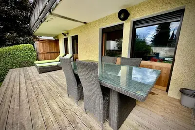 a glass table and chairs on a wooden deck at Appartement Rothschild - garage - Welkeys in Megève