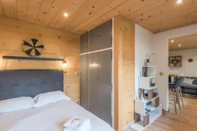 a bedroom with a bed and a wooden wall at Appartement Rothschild - garage - Welkeys in Megève