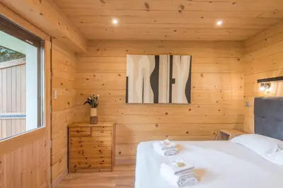 a bedroom with wooden walls and a bed with towels at Appartement Rothschild - garage - Welkeys in Megève