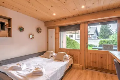 a large bed in a room with a large window at Appartement Rothschild - garage - Welkeys in Megève