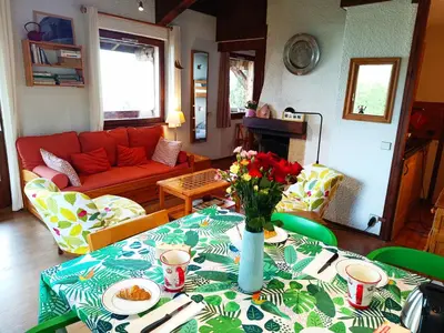 a living room with a table with a vase of flowers on it at Le Tavaillon in Saint-Gervais-les-Bains