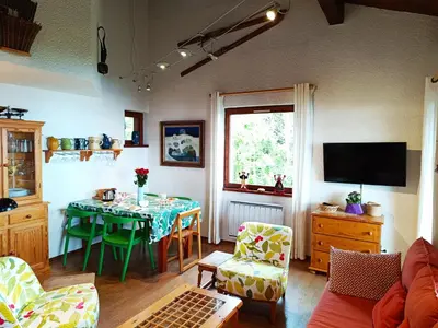 a living room with a table and a television at Le Tavaillon in Saint-Gervais-les-Bains