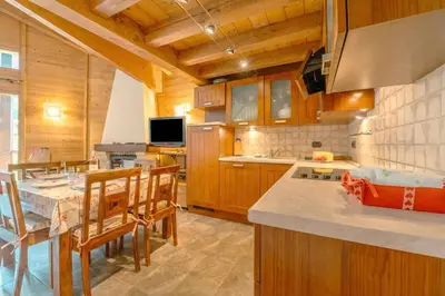 a kitchen with wooden cabinets and a table and chairs at Appartement Des Granges - Happy Rentals in Chamonix-Mont-Blanc
