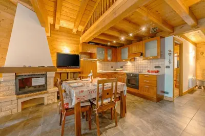 a kitchen with a table and chairs and a fireplace at Appartement Des Granges - Happy Rentals in Chamonix-Mont-Blanc