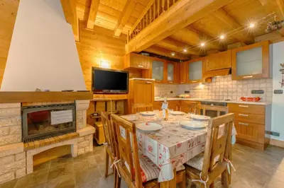a kitchen with a table with chairs and a fireplace at Appartement Des Granges - Happy Rentals in Chamonix-Mont-Blanc